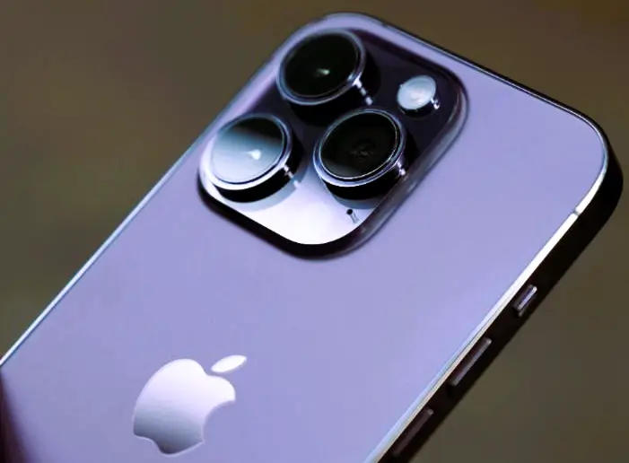 Close-up of iPhone 15 Pro Max showcasing its triple camera module and Apple logo on a metallic body