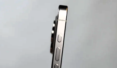 Side view of iPhone 15 Pro Max showcasing its metallic edge and three side buttons against a grey background