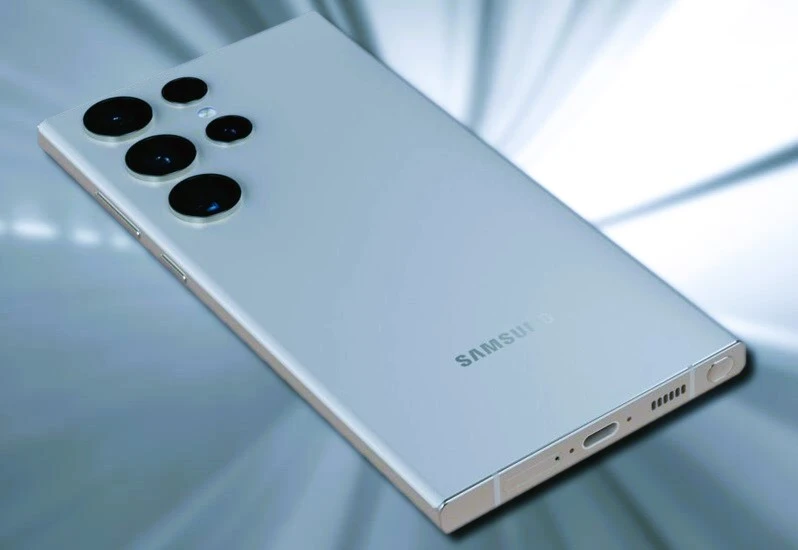 A close-up photo of the front of a white Samsung Galaxy S22 Ultra smartphone. The phone has a large, edge-to-edge display and a small punch-hole cutout for the selfie camera.