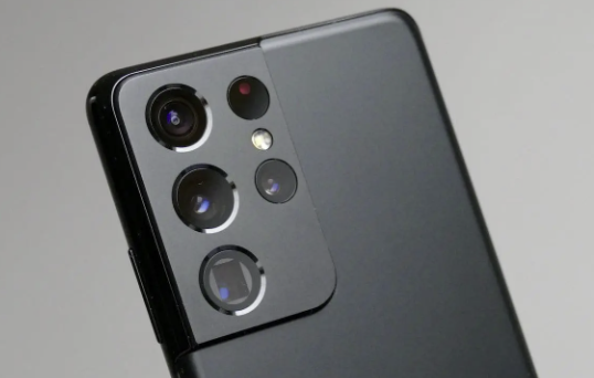a close-up view of the upper corner of a sleek black smartphone, presumably the Samsung Galaxy S22 Ultra. The focus is on the camera module, which consists of four vertically arranged lenses and sensors. Each lens varies in size, suggesting different functionalities for versatile photography.